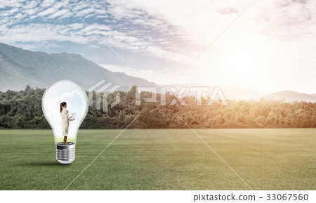 Businesswoman inside light bulb Businesswoman inside light bulb 33067560