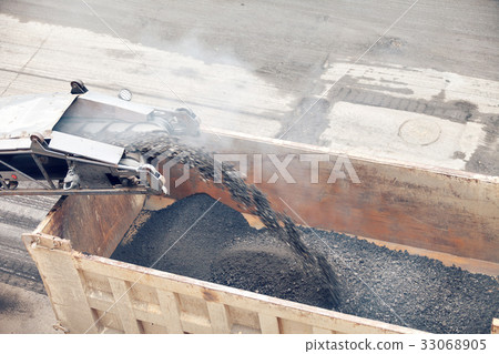 Road works. Asphalt removing machine loading 33068905