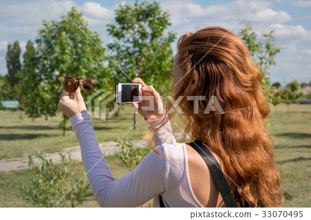 model photographing themselves with smartphone 33070495