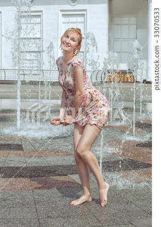Wet woman is drying her dress. Wet woman is drying her dress. 33070533