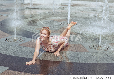 Wet woman lies in a fountain. Wet woman lies in a fountain. 33070534