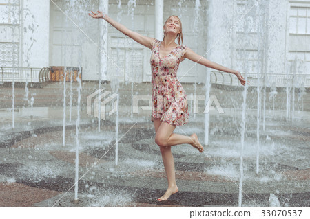 Happy woman frolics in a fountain. Happy woman frolics in a fountain. 33070537