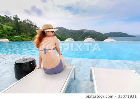 Woman in bikini sitting on the swimming pool Woman in bikini sitting on the swimming pool 33071931