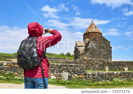 Woman with backpack taking photo of ancient Woman with backpack taking photo of ancient 33074378