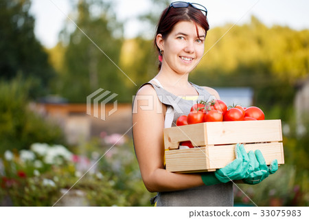 Brunette holding box with tomatoes 33075983
