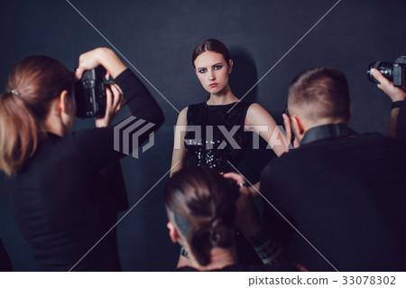 Photographers paparazzi take photos of beautiful 33078302