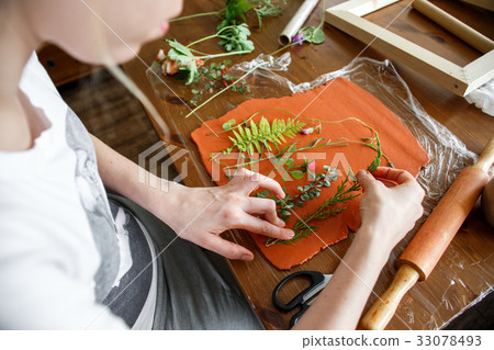 Woman making botanical plaster artwork in her home Woman making botanical plaster artwork in her home 33078493