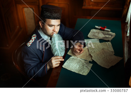 Man is thinking when he wrote the manuscript. 33080787