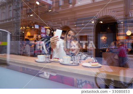 Young woman and little girl making selfie in cafe Young woman and little girl making selfie in cafe 33080853