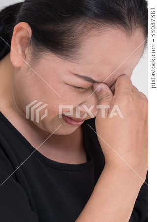 stressed middle aged woman with headache, tension 33087381