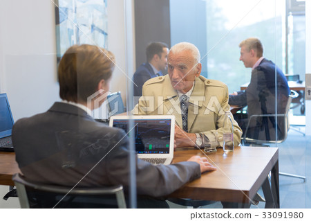 Financial advisor consulting senior client with 33091980