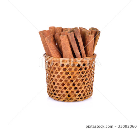 dried cinnamon in basket and on white background dried cinnamon in basket and on white background 33092060