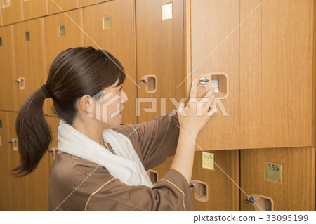 把行李放的婦女在溫泉設施衣物櫃裡 33095199