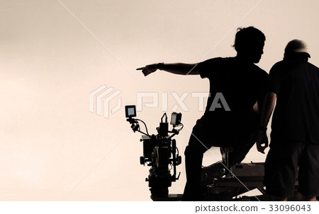 Silhouette behind the scenes of camera man. 33096043