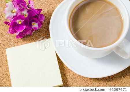 Cup of coffee with flowers on cork board. Cup of coffee with flowers on cork board. 33097671