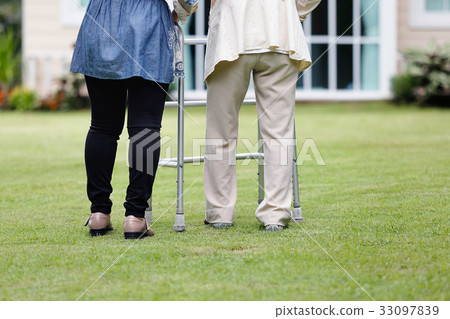 Elderly woman walking in backyard with daughter 33097839