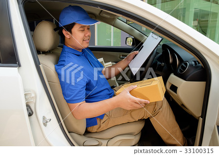 Delivery driver driving with parcels on seat. Delivery driver driving with parcels on seat. 33100315