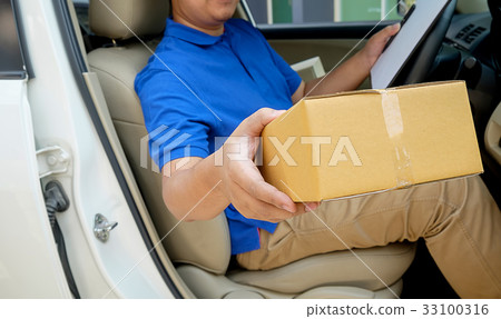 Delivery driver driving with parcels on seat Delivery driver driving with parcels on seat 33100316