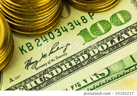 The hundred dolllar banknote with stack of coins The hundred dolllar banknote with stack of coins 33103217