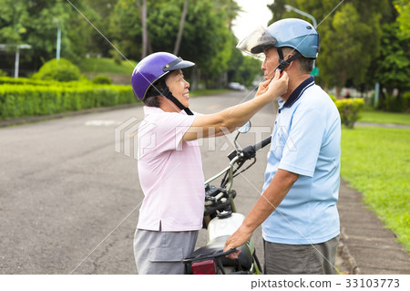 grandmother help grandfather to wear a helmet grandmother help grandfather to wear a helmet 33103773