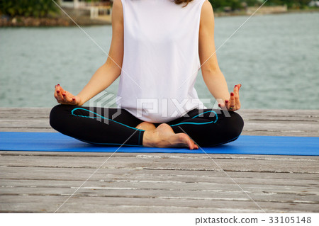Woman is exercise yoga and meditation at pier 33105148