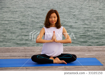 Woman is exercise yoga and meditation at pier Woman is exercise yoga and meditation at pier 33105150