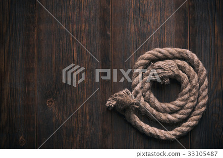 Twisted rope on a wooden floor 33105487
