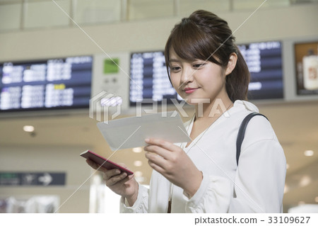 Woman checking air ticket in airport lobby 33109627