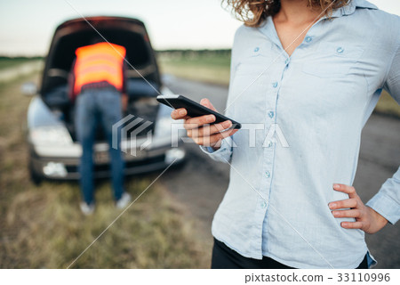 Woman calls to service, man repair broken car 33110996