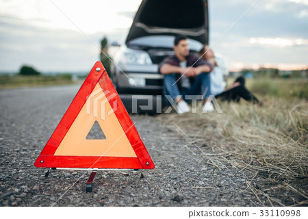 Broken car concept, man sitting on tire Broken car concept, man sitting on tire 33110998
