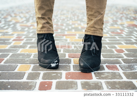 Female feet in an elegant black winter boots Female feet in an elegant black winter boots 33111332