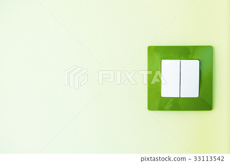 White light switch on a green wall White light switch on a green wall 33113542