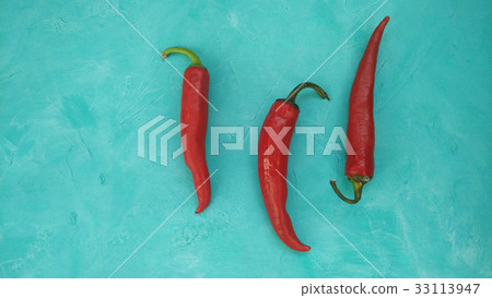 Red hot chili peppers on teal background 33113947