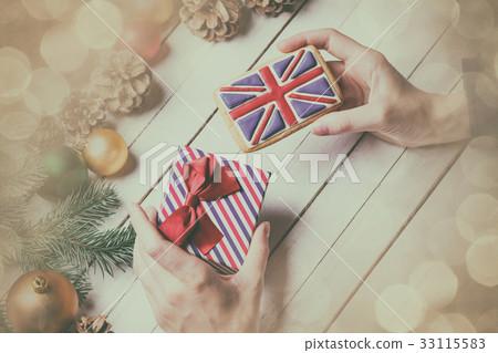 female hands holding a cookie and gift 33115583