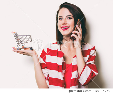 young woman with cart and mobile phone 33115739