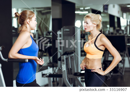 Two athletic blond women talking in the gym. Girl Two athletic blond women talking in the gym. Girl 33116907