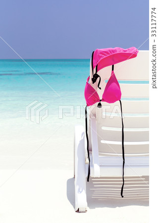Swimsuit hanging on white chaise longue Swimsuit hanging on white chaise longue 33117774
