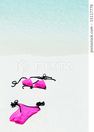 Swimsuit lying on white sand close to sea Swimsuit lying on white sand close to sea 33117776