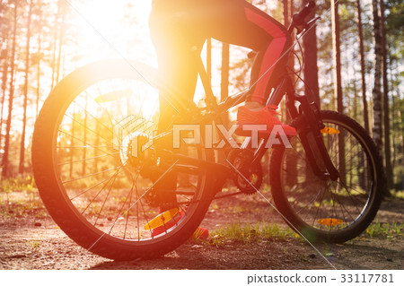 Woman riding a mountain bicycle at the forest Woman riding a mountain bicycle at the forest 33117781