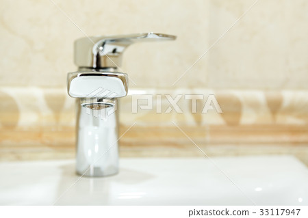 Modern metal faucet in bathroom 33117947