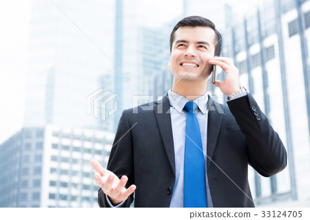 Businessman calling on smartphone in the city 33124705