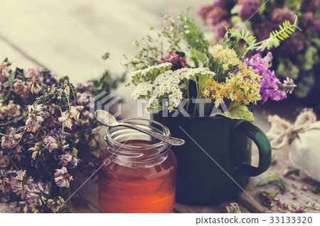Mug of healing herbs, old tea kettle, honey jar. 33133320