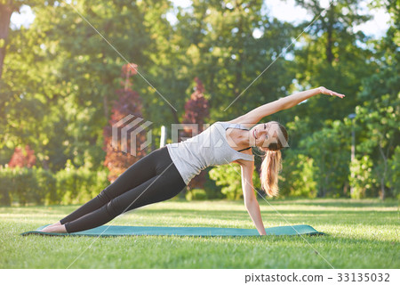 Young woman practicing yoga outdoors at the park 33135032