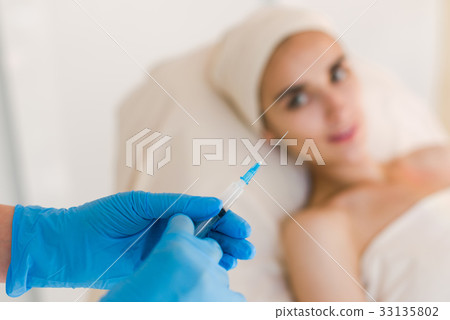Doctor making botox facial injection. 33135802