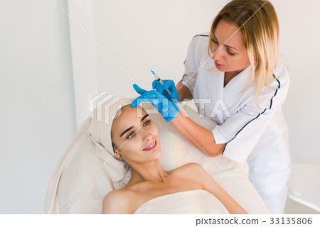Doctor making botox facial injection. 33135806