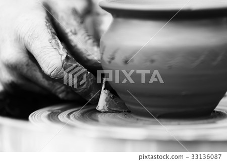 Potter making ceramic pot on the pottery wheel 33136087