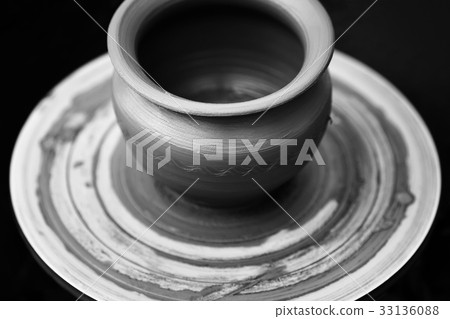 Potter making ceramic pot on the pottery wheel 33136088