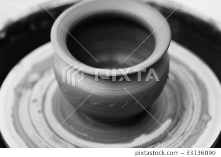 Potter making ceramic pot on the pottery wheel 33136090