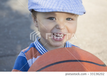 a little boy holds a basketball a little boy holds a basketball 33136202