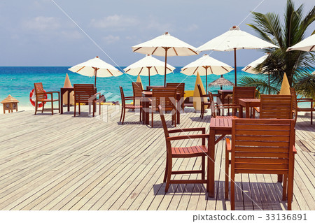 Wooden furniture with tables and chairs on terrace 33136891